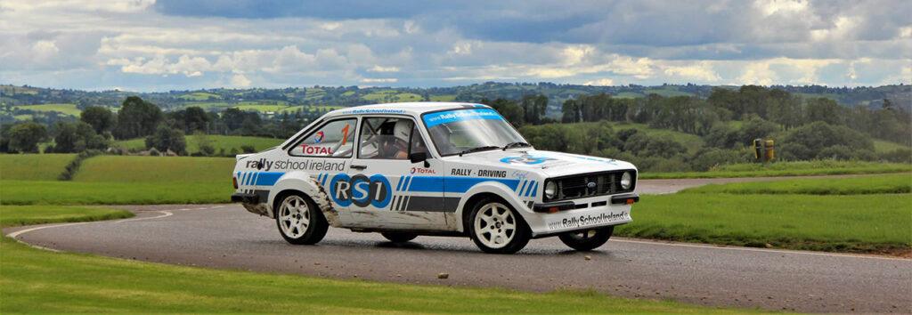 Classic rally car in action at Rally School Ireland, speeding through a scenic countryside track.
